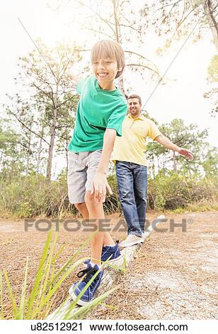 Father and son (12-13) balancing on log View Large Photo Image Stock Image - Father and son (12-13) balancing on log. Fotosearch