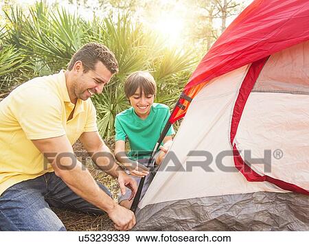 Father and son (12-13) setting up tent View Large Photo Image Stock Photo - Father and son (12-13) setting up tent. Fotosearch