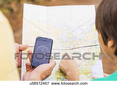 Father and son (12-13) using smartphone app and map View Large Photo Image Stock Photo - Father and son (12-13) using smartphone app and map. Fotosearch