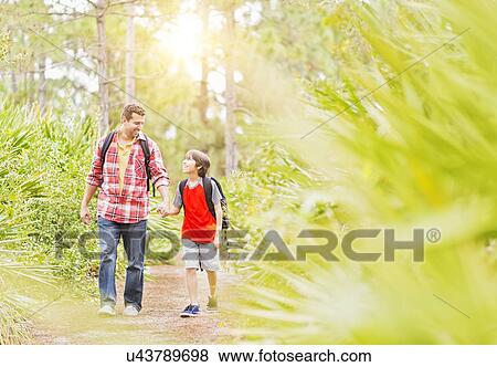 Father and son (12-13) walking in forest View Large Photo Image Stock Photo - Father and son (12-13) walking in forest. Fotosearch