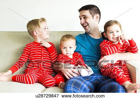 Stock Photo - "Father with children (2-3, 4-5) in red pajamas". Fotosearch