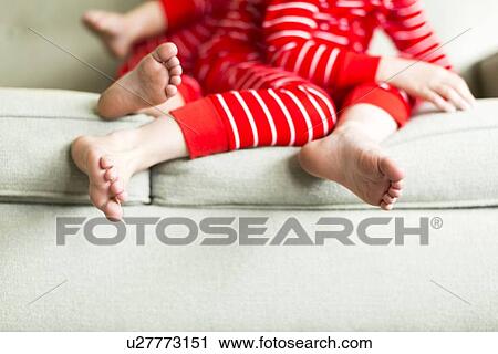 Stock Image - "Feet of siblings (2-3, 4-5) in red pajamas". Fotosearch