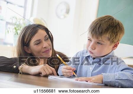 Female teacher and schoolboy (6-7) in classroom View Large Photo Image Stock Image - Female teacher and schoolboy (6-7) in classroom. Fotosearch