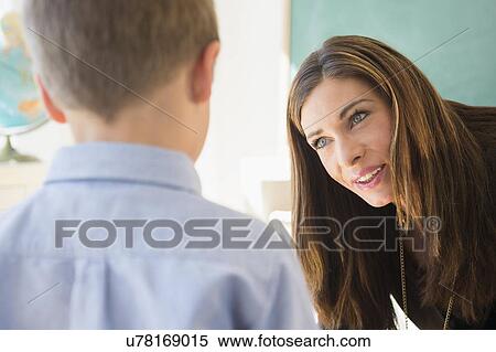 Stock Photography - Female teacher and schoolboy (6-7) in classroom. Fotosearch