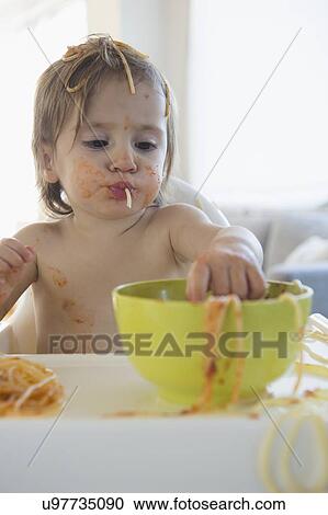 Stock Image - Girl (2-3) eating spaghetti. Fotosearch