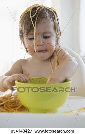 Stock Photo - Girl (2-3) eating spaghetti. Fotosearch