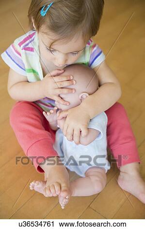 Girl (2-3) hugging her doll View Large Photo Image Stock Image - Girl (2-3) hugging her doll. Fotosearch