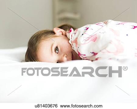 Stock Photograph - Girl (2-3) lying on bed. Fotosearch