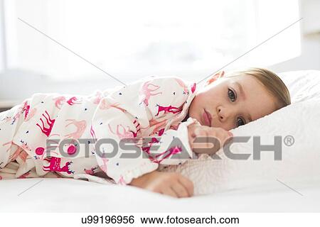 Girl (2-3) lying on bed View Large Photo Image Stock Photograph - Girl (2-3) lying on bed. Fotosearch