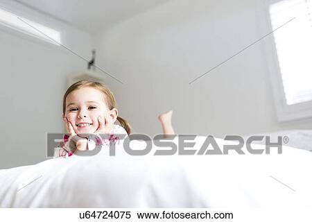 Stock Photography - Girl (2-3) lying on bed. Fotosearch
