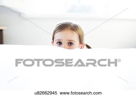 Stock Photography - Girl (4-5) peeking over bed edge. Fotosearch