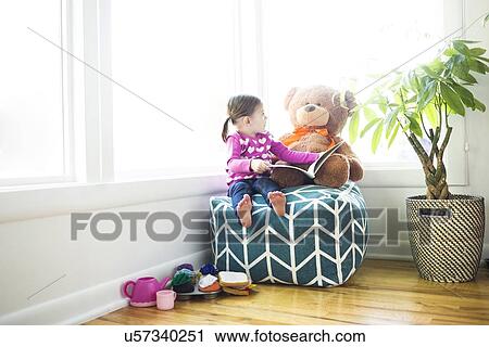 Girl (4-5) sitting with teddy bear on bean bag View Large Photo Image Stock Image - Girl (4-5) sitting with teddy bear on bean bag. Fotosearch