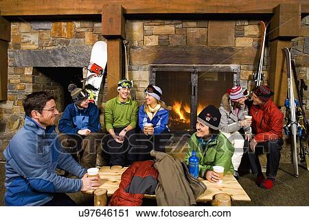 Group of skiers hanging out at fireplace View Large Photo Image Stock Image - Group of skiers hanging out at fireplace. Fotosearch
