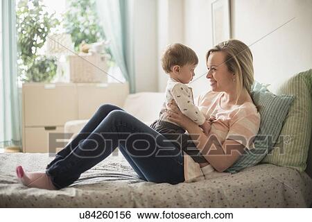 Happy mother playing with little son (2-3 years) on bed View Large Photo Image Stock Photograph - Happy mother playing with little son (2-3 years) on bed. Fotosearch