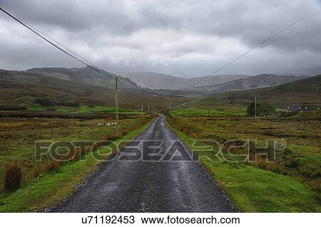 "Landscape with asphalt road and green grass, clouds in sky, hills in background" View Large Photo Image Stock Image - "Landscape with asphalt road and green grass, clouds in sky, hills in background". Fotosearch