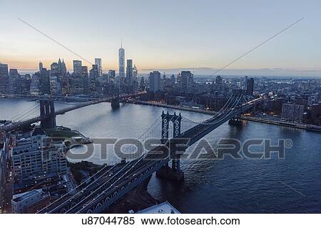 Stock Photography - "Lower Manhattan, View of Brooklyn Bridge and One World Trade Center at dusk". Fotosearch