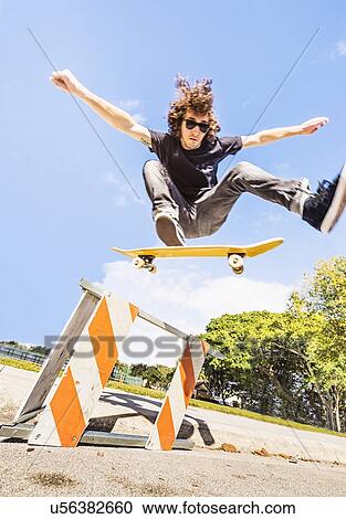 Man jumping on skate board in construction site View Large Photo Image Stock Image - Man jumping on skate board in construction site. Fotosearch