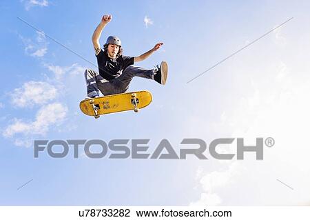 Man jumping on skateboard against sky and clouds View Large Photo Image Stock Image - Man jumping on skateboard against sky and clouds. Fotosearch