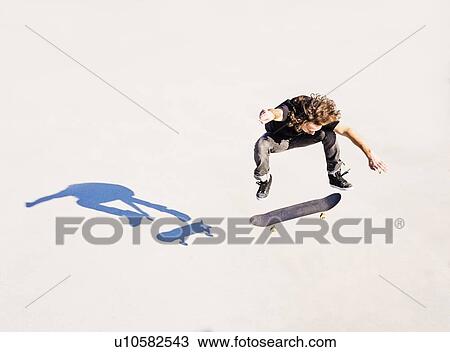 Man jumping on skateboard in skatepark View Large Photo Image Stock Image - Man jumping on skateboard in skatepark. Fotosearch