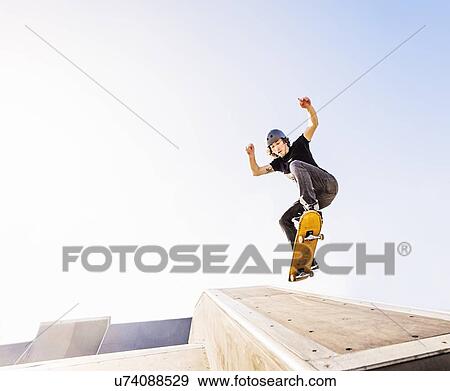 Man jumping on skateboard in skatepark View Large Photo Image Stock Photo - Man jumping on skateboard in skatepark. Fotosearch