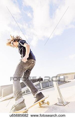 Stock Image - Man skateboarding in skatepark. Fotosearch