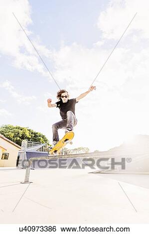 Man skateboarding in skatepark View Large Photo Image Stock Photograph - Man skateboarding in skatepark. Fotosearch