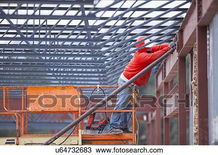 Man working at construction site View Large Photo Image Stock Image - Man working at construction site. Fotosearch