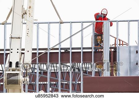 Stock Image - Man working at construction site. Fotosearch