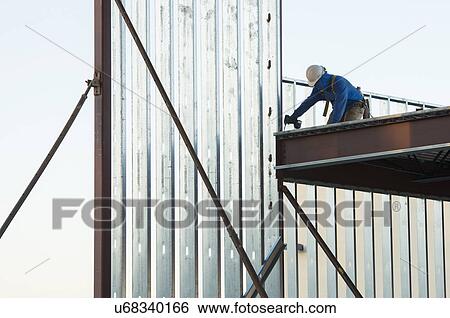 Man working at construction site View Large Photo Image Stock Photograph - Man working at construction site. Fotosearch