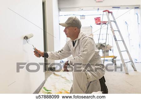 Stock Photo - Manual worker painting wall. Fotosearch