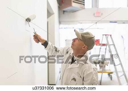 Stock Photograph - Manual worker painting wall. Fotosearch