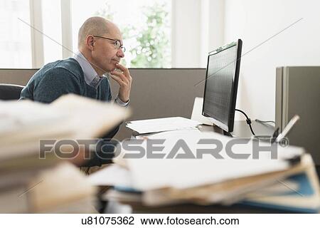 Stock Image - Mature businessman working in office. Fotosearch