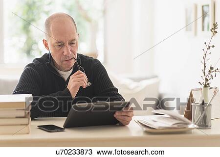 Mature man working in home office View Large Photo Image Stock Image - Mature man working in home office . Fotosearch
