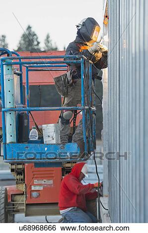 Stock Photograph - Men welding steel bar. Fotosearch