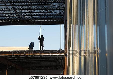 Stock Photography - Men working at construction site. Fotosearch