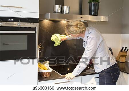 Mid-adult woman cleaning kitchen View Large Photo Image Stock Photograph - Mid-adult woman cleaning kitchen. Fotosearch