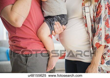 Mid-section of parents with son (2-3) in living room View Large Photo Image Stock Photography - Mid-section of parents with son (2-3) in living room. Fotosearch