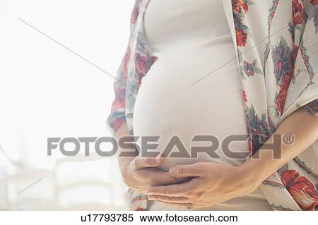 Stock Photography - Mid-section of pregnant woman . Fotosearch