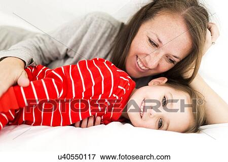 Stock Photo - Mom and daughter (2-3) lying in bed. Fotosearch
