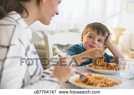 Mother and son (6-7) eating spaghetti View Large Photo Image Stock Photo - Mother and son (6-7) eating spaghetti . Fotosearch
