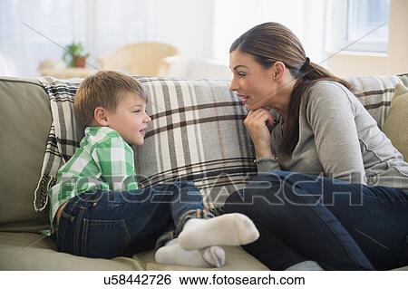Mother and son (6-7) sitting on sofa View Large Photo Image Stock Photograph - Mother and son (6-7) sitting on sofa . Fotosearch