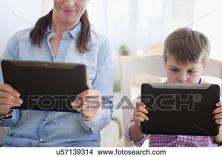 Mother and son (6-7) using digital tablet View Large Photo Image Picture - Mother and son (6-7) using digital tablet . Fotosearch