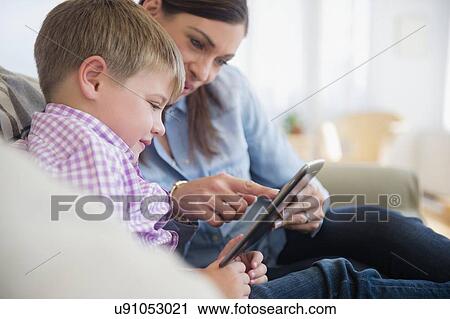Stock Image - Mother and son (6-7) using digital tablet . Fotosearch