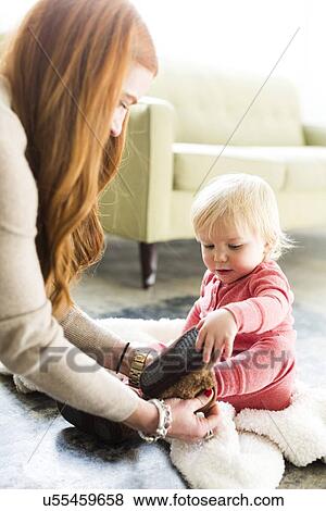 Mother dressing son (2-3) in living room View Large Photo Image Stock Photo - Mother dressing son (2-3) in living room. Fotosearch