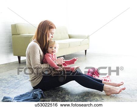 Mother dressing son (2-3) in living room View Large Photo Image Stock Photograph - Mother dressing son (2-3) in living room. Fotosearch