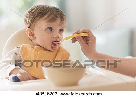 Mother feeding small boy (2-3) with spoon View Large Photo Image Stock Photo - Mother feeding small boy (2-3) with spoon. Fotosearch