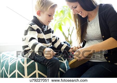 Mother helping son (6-7) putting shoe on View Large Photo Image Stock Image - Mother helping son (6-7) putting shoe on. Fotosearch