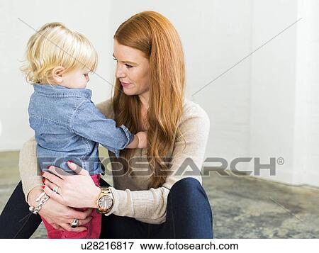 Stock Photo - Mother sitting on floor embracing boy (2-3). Fotosearch