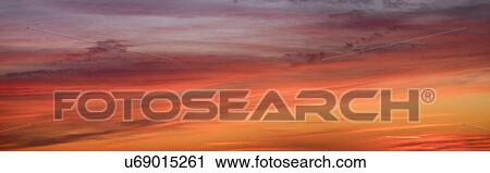 Stock Image - Panoramic view of sunrise sky with clouds. Fotosearch