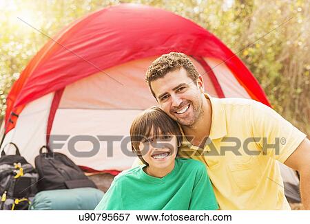 Stock Photo - Portrait of father and son (12-13) camping. Fotosearch